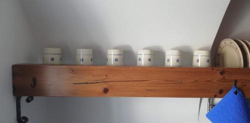 a wooden shelf with a row of cups on it at CASA DI 'NZUSU in Carovigno