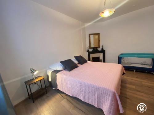 a bedroom with a bed and a table and a mirror at Les Maisons du Conflent, maisons familiales en pierre au coeur des remparts in Villefranche-de-Conflent