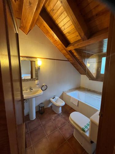 a bathroom with a sink and a toilet and a tub at Hotel Els Encantats in Espot