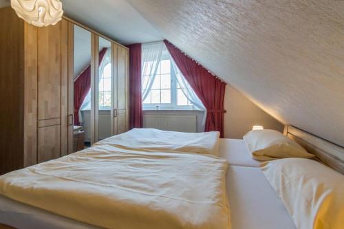 ノルトダイヒにあるFerienwohnung Büscherのベッドルーム1室(窓、白いベッド1台付)