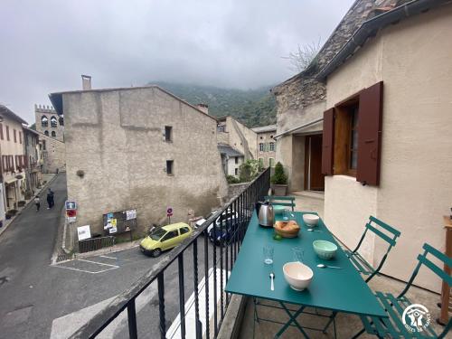 a blue table on a balcony with a yellow car at Les Maisons du Conflent, maisons familiales en pierre au coeur des remparts in Villefranche-de-Conflent
