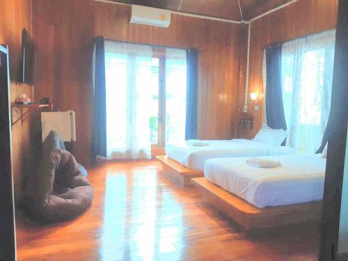 a bedroom with two beds and a large window at Srisanor Boutique Hotel in Prachuap Khiri Khan