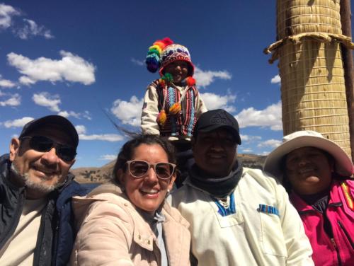 a group of people posing for a picture with a child on top at TITICACA JALTAWI LODGE in Puno