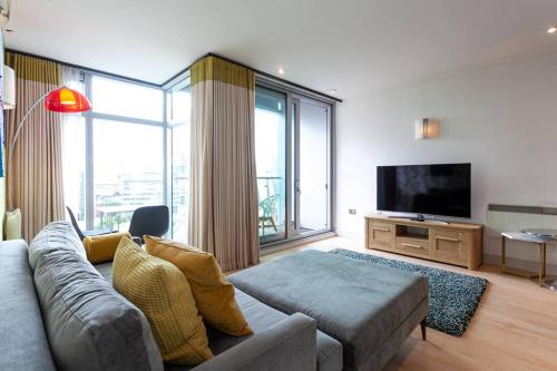 Una sala de estar con un sofá y un televisor de pantalla plana. en Iconic Luxury Manchester Apartment, en Mánchester