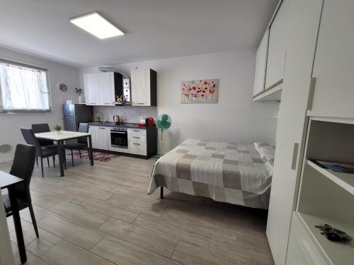 ein Schlafzimmer mit einem Bett und eine Küche mit einem Tisch in der Unterkunft Le Rondini in Barlassina