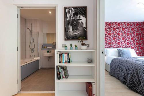 ein Schlafzimmer mit einem Bett und ein Badezimmer mit einer Dusche in der Unterkunft Iconic Luxury Manchester Apartment in Manchester