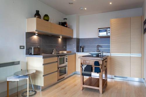 una cocina con fregadero y encimera. en Iconic Luxury Manchester Apartment, en Mánchester