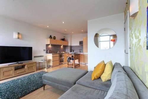 a living room with a couch and a flat screen tv at Iconic Luxury Manchester Apartment in Manchester