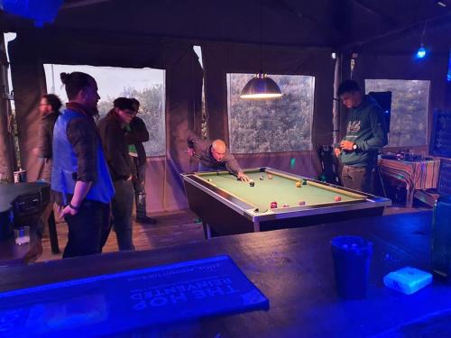 a group of people standing around a pool table at Mulberry Lane in Richmond