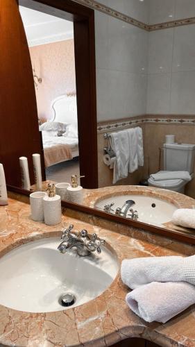 a bathroom with a sink and a large mirror at Villa Avoti in Sigulda