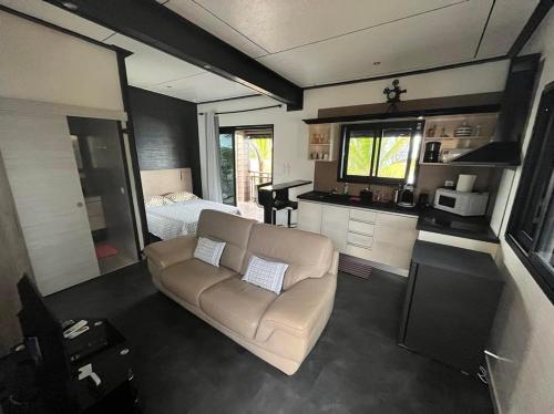 ein Wohnzimmer mit einem Sofa und einem Bett in der Unterkunft Ti case bord de mer in Saint-Benoît
