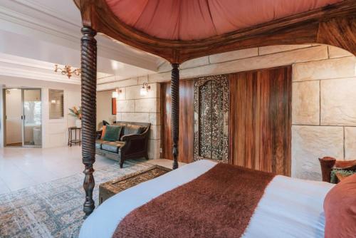 a bedroom with a canopy bed and a living room at Olinda Sandstone Apartment 2 Bedroom Spa bath in Olinda