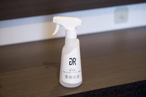 a white bottle of hair lotion sitting on a table at Green Rich Hotel Izumo (Artificial hot spring Futamata Yunohana) in Izumo