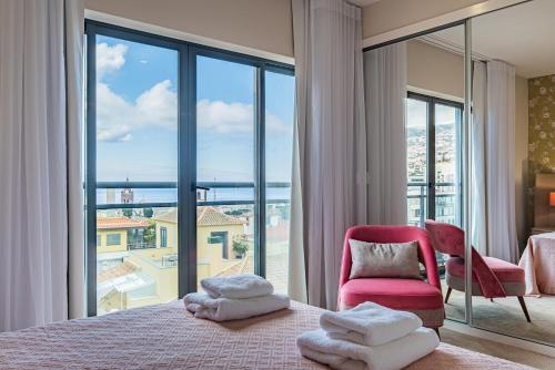 um quarto com uma cama e uma grande janela em Urban Paradise by Madeira Sun Travel em Funchal
