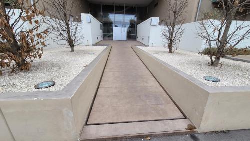 a walkway leading into a building with trees in it at Le Rondini in Barlassina