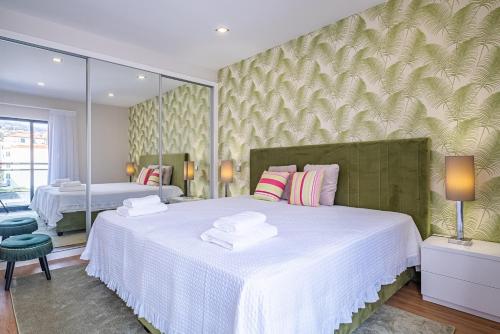 a bedroom with two beds and a large mirror at Urban Paradise by Homie in Funchal