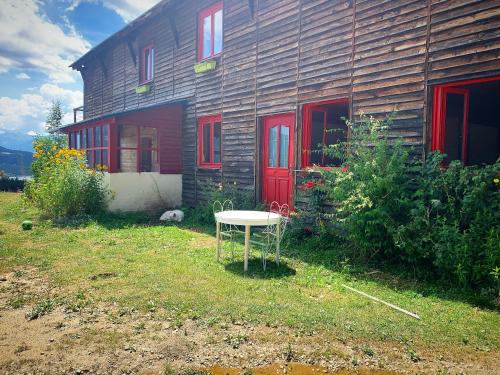 a table in front of a house with a red door at Gîte Ranch Le Serpolet in Les Angles