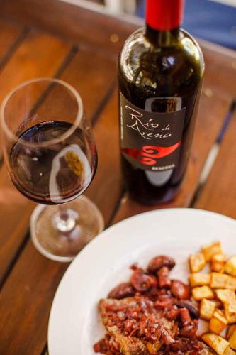 a plate of food and a bottle of wine on a table at Estancia Rio de Arena in Colalao del Valle