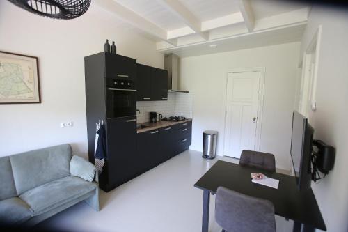 een woonkamer met een bank en een tafel bij Recreatieappartement BoerdeRijlst - De Kamer in Sint Nicolaasga