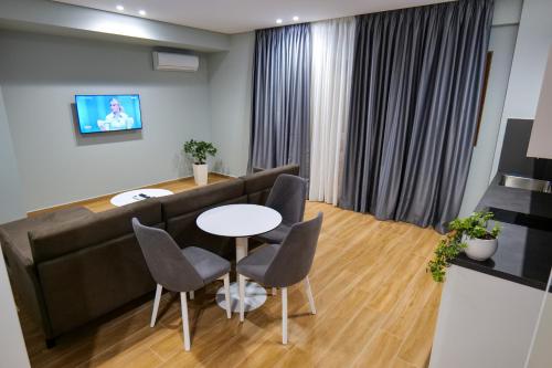 a living room with a couch and a table and chairs at Sky Way SKK Luxury Apartments in Sarandë