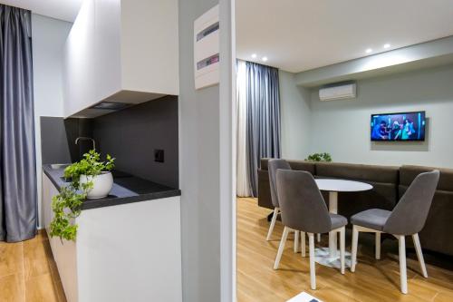 a dining room and living room with a table and chairs at Sky Way SKK Luxury Apartments in Sarandë