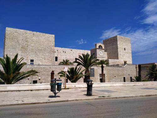 a large brick building with two parking meters in front of it at Monolocale prezioso in Trani