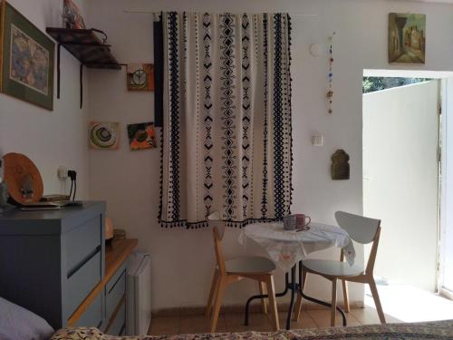 una camera con tavolo, sedie e finestra di מקום קטן בשלווה a little peaceful place ad Arad