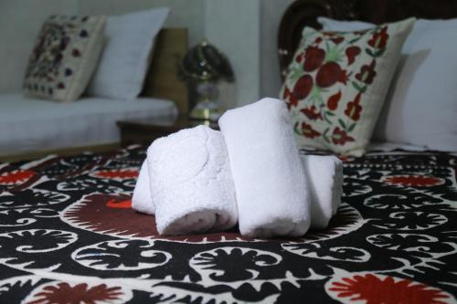 dos toallas sentadas encima de una cama en Samarkand City Center Hotel, en Samarkand