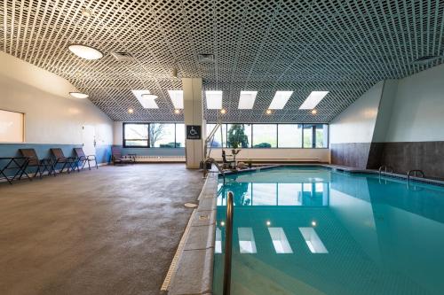 a swimming pool in a large room with a pool at APA Hotel Woodbridge in Iselin