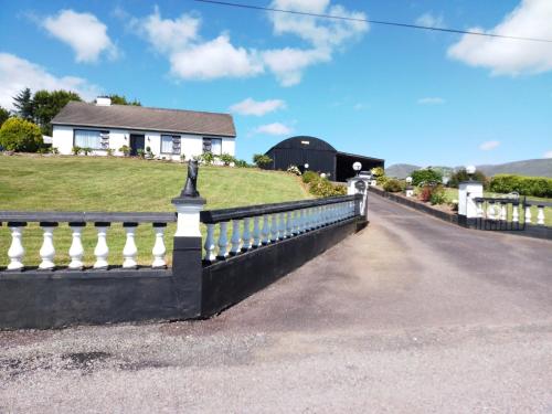 a black and white fence in front of a house at Room in Bungalow - Very Nice View With This Room in Sneem