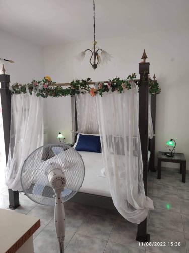 a bedroom with a bed with a canopy at Myrtia Guest House in Pýrgos