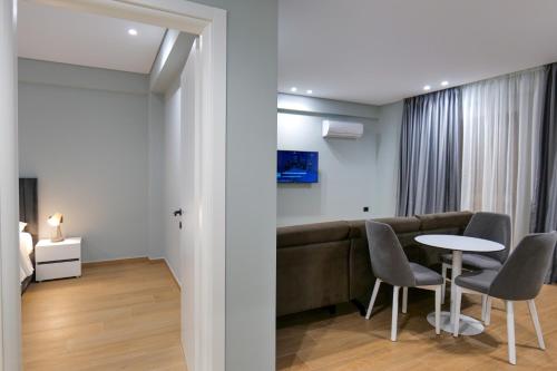 a living room with a couch and a table and chairs at Sky Way SKK Luxury Apartments in Sarandë