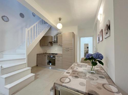 a kitchen with a table with a vase of flowers on it at Comfort Cher a Cadorago in Fino Mornasco
