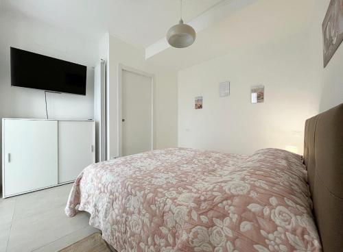 um quarto com uma cama e uma televisão de ecrã plano em Alloggio confortevole a Cadorago em Fino Mornasco