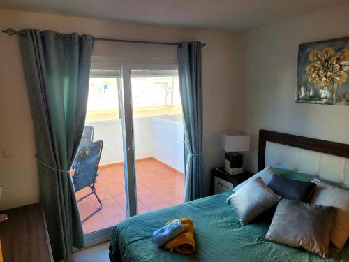 a bedroom with a bed and a sliding glass door at JARDIN 8 JOZMAR in Alhama de Murcia