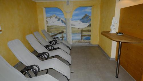 a row of chairs in a room with a painting at Landhaus Franzelin in Längenfeld