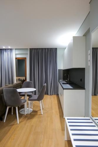 a kitchen and a living room with a table and chairs at Sky Way SKK Luxury Apartments in Sarandë
