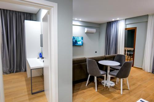 a living room with a couch and a table and chairs at Sky Way SKK Luxury Apartments in Sarandë