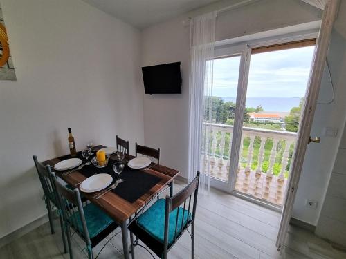 a dining room with a table and a large window at Apartment House Kastelan in Banjol