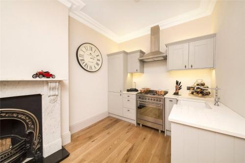 a kitchen with a large clock on the wall at Luxurious 1-bedroom apartment. Indoor Fireplace in South Norwood