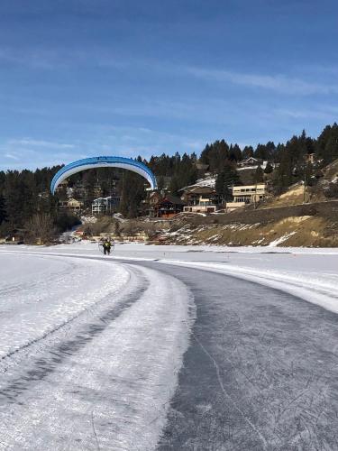 a road covered in snow with a blue bridge in the background at Perfect base Invermere 3bd townhouse mt views with garage in Invermere