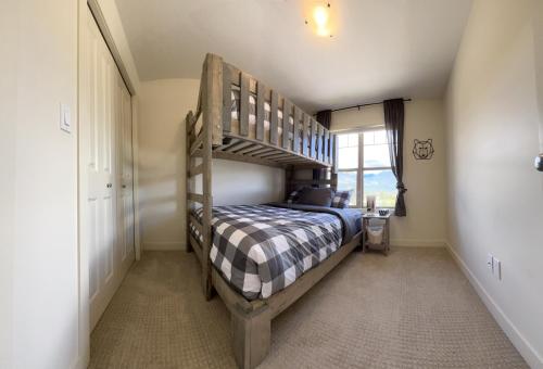 a bedroom with a bunk bed and a window at Perfect base Invermere 3bd townhouse mt views with garage in Invermere