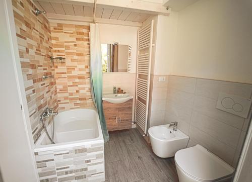 La salle de bains est pourvue d'une baignoire, de toilettes et d'un lavabo. dans l'établissement LibertySuite Qcview2, à San Pellegrino Terme