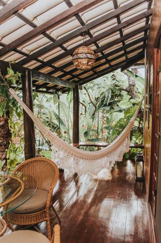 a hammock in the middle of a room with plants at Ananda Pousada in Pirenópolis
