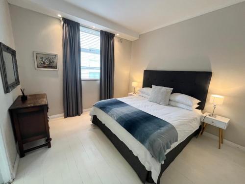 a bedroom with a large bed and a window at Seapoint Gem in Cape Town