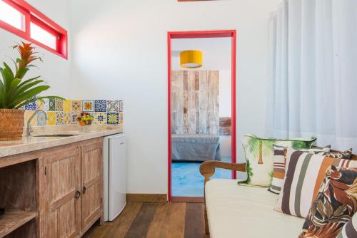 a living room with a couch and a sink at Pousada Rosa dos Ventos in Praia do Forte