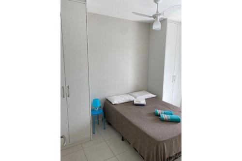 a small bedroom with a bed and a blue chair at Lazer completo 150 mts praia - apto novo Maitinga in Bertioga