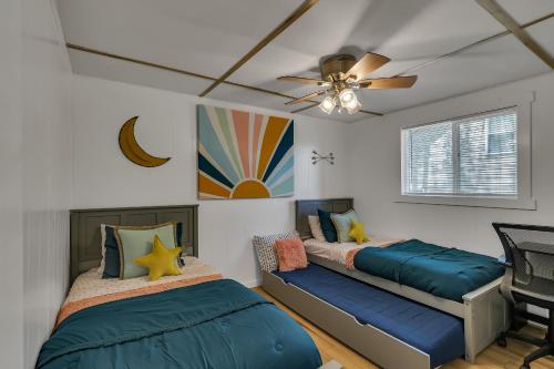 a bedroom with two beds and a ceiling fan at Firefly Cottage cabin in Reeds Spring