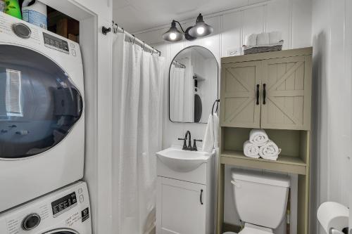 y baño con aseo, lavabo y lavadora. en Firefly Cottage cabin, en Reeds Spring