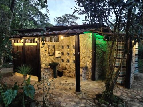 a small stone building with a green light at Finca de la Vaca - Glamping in Palora